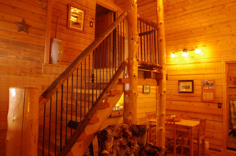 Log stair case to loft in Bunkhouse bedroom at Historic Reesor Ranch.